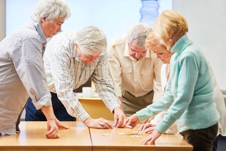Group of seniors with dementia playing the puzzle as memory training in a retirement homeの写真素材