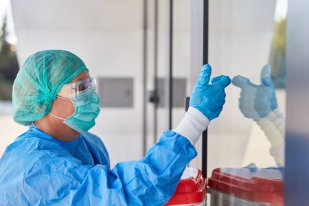 Doctor or surgeon during organ transport for surgery in front of the clinic in protective clothing...