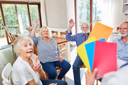 Seniors do an exercise in group psychotherapy at the retirement home