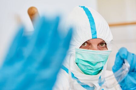 Doctor in protective clothing in clinic shows hand as keep distance sign during coronavirus pandemicの写真素材