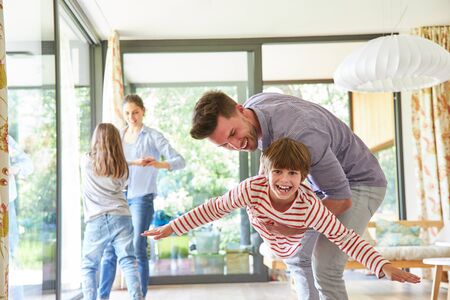 Parents play and romp with their happy children in the living roomの写真素材
