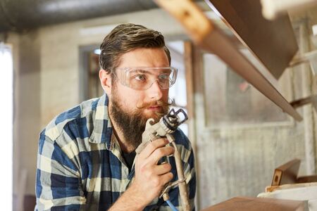 Craftsman as a painter when painting wood with a paint spray systemの写真素材