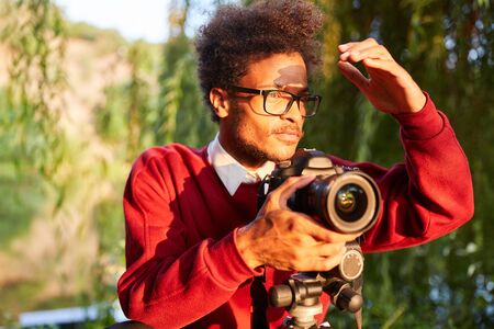 Landscape photographer with digital camera in backlight in the green natureの写真素材