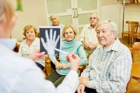 Doctor on an information evening for seniors about health and prevention