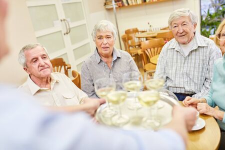 White wine is served at a celebration in the retirement home or at the senior meetingの写真素材