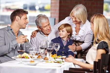 Happy family with three generations together in the restaurantの写真素材
