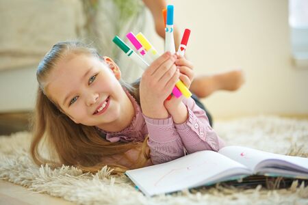 Smiling child with lots of colorful pencils for painting