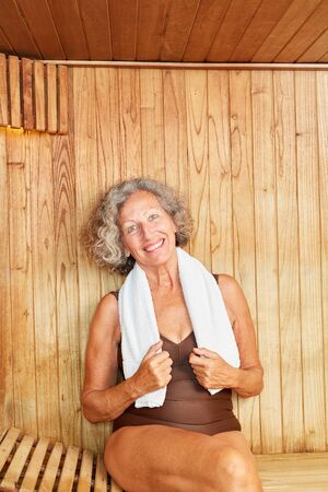 Happy senior woman sitting relaxed in the sauna at the wellness hotelの写真素材