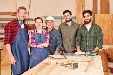 Carpenter team with senior boss and artisan apprentices together in the workshopの写真素材