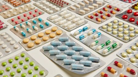 Selection of various colorful tablets and medicines drugs on a table