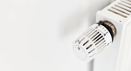 Temperature regulator with thermostat on radiator from a white heaterの写真素材
