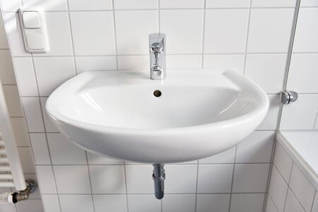 Ceramic bathroom sink with faucet and white tiles at homeの写真素材