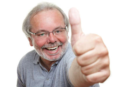 Cheering laughing pensioner holds his thumb up