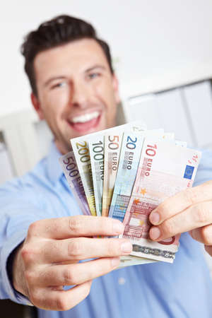 Laughing winner with fan of money from euro bills