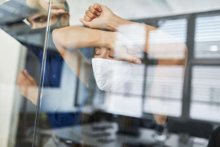 Exhausted businesspeople with facial mask because of Covid-19 after layoff or short-time work