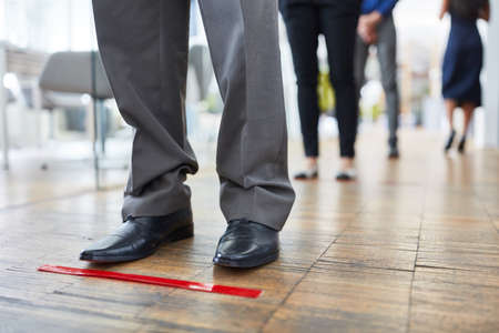 Adhesive tape as a distance marker for employees in the office to keep them away as infection protectionの写真素材