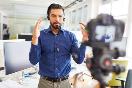 Businessman as a coach recording a teaching video for an internet tutorial streamingの写真素材