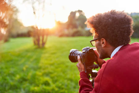 Photographer as a landscape photographer with camera while photographing in natureの写真素材