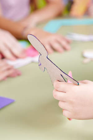 Children tinker in kindergarten with a template in hand