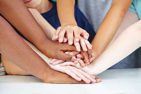 Children show friendship and cohesion with their hands as a stack