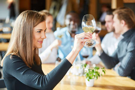 Young woman at a wine seminar tasting with a glass of white wine
