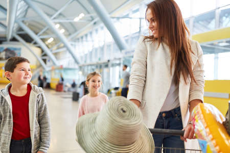 Mother with two children and luggage in the airport terminal are looking forward to the holiday tripの写真素材