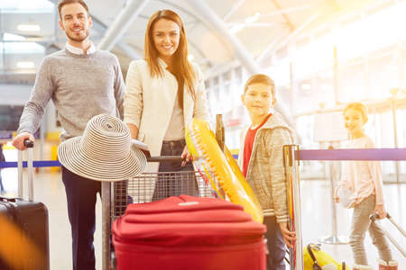 Family with two children at the airport on departure for summer vacationの写真素材