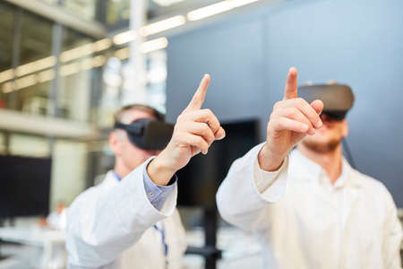 Scientist with VR glasses learning and exercising in 3D simulation for medicine researchの写真素材