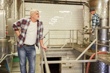 Elderly winemaker supervises the wine production in the winery