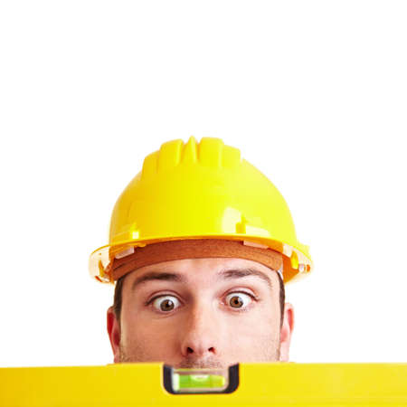 Craftsman looks in amazement at a yellow spirit levelの写真素材