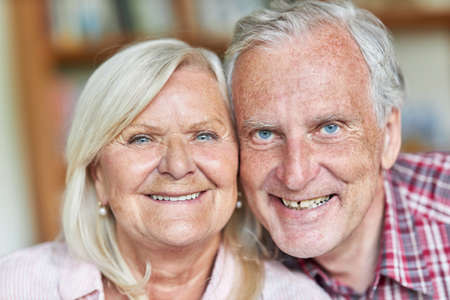 Senior couple smiling happily at the camera