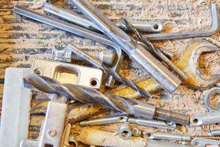 Different drills and wrenches between sawdustの写真素材