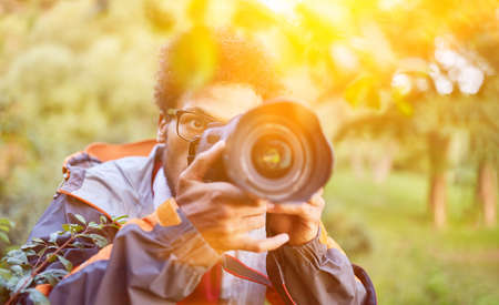 Papparazi photographer taking pictures in nature with cameraの写真素材