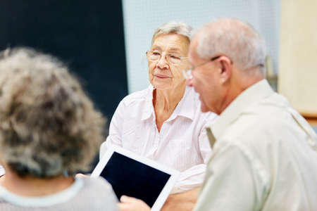 Group of seniors learn together how to use computers and the Internet