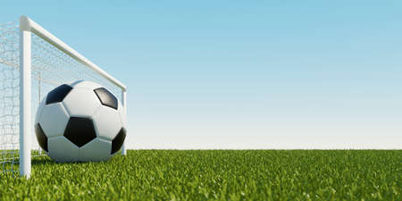 Huge soccer ball in goal of soccer field in front of a blue sky (3D rendering)の写真素材