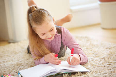 Child paints a picture at home with a felt pen