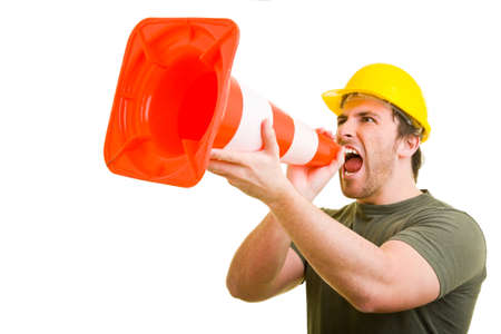 Construction worker shouts into a pylonの写真素材