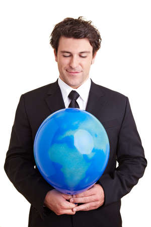 Businessman holding a balloon with a world globe printed on itの写真素材