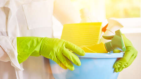 Hands of cleaning lady or cleaner with cleaning products during spring cleaning