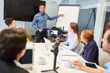 African business man in meeting while streaming live with video cameraの写真素材