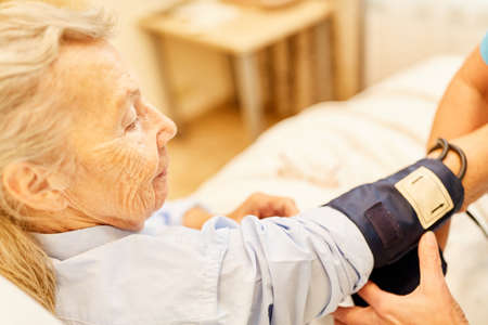 Blood pressure measurement at a senior nursing woman in a nursing home
