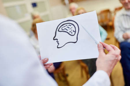 Female doctor with a drawing of the brain gives a lecture on dementia and memory