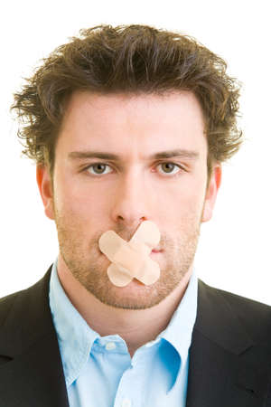 Young man in a suit with a plaster on his mouthの写真素材