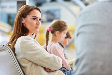 Woman as a passenger is waiting bored in the rest area in the airport terminal before departureの写真素材