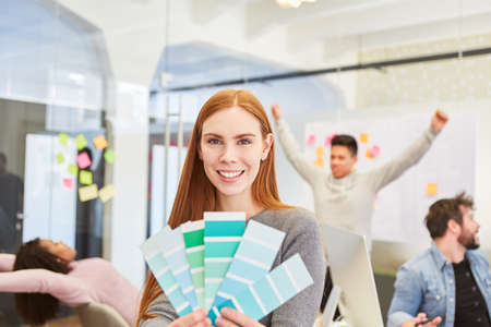 Smiling woman as a graphic designer with color palette in a meeting in the design agencyの写真素材