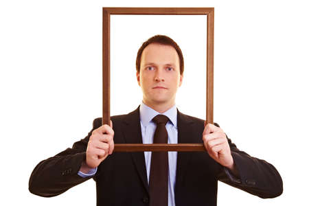 Businessman looking through an empty wooden frame
