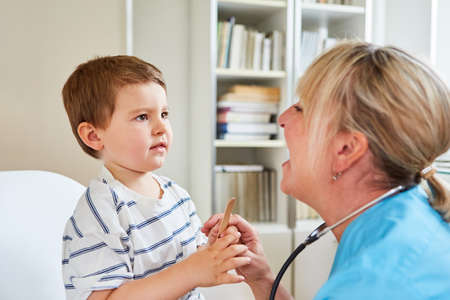 Pediatrician and child with tonsillitis or sore throat during an examinationの写真素材