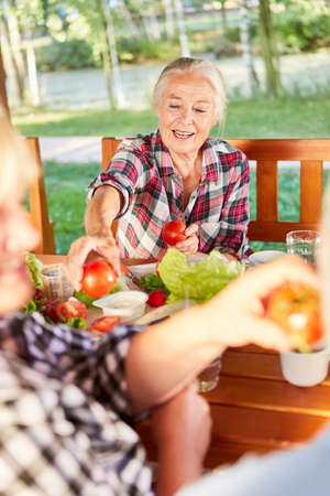 Seniors eat healthy organic tomatoes for brunch or breakfast on vacationの写真素材