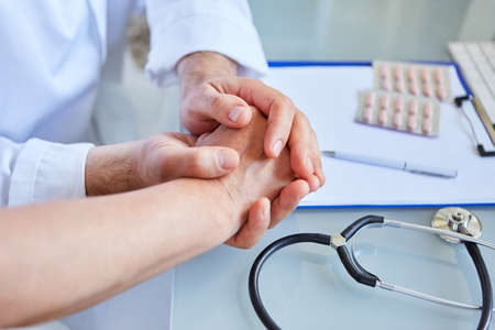 Female doctor holds patient's hand in her hands as a concept of comfort and confidence