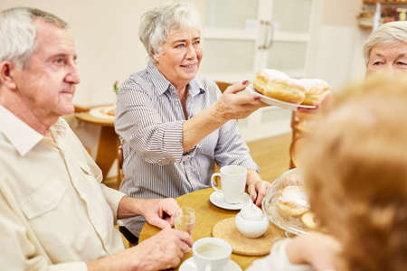 Seniors having a coffee in a retirement home eat Berlin pancakes